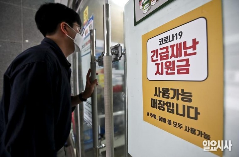 최근 코로나 국민 재난지원금과 관련해 신 계급사회 논란이 일고 있는 가운데 한 서울 시민이 긴급재난 지원금 사용이 가능한 매장을 들어서고 있다. ⓒ고성준 기자